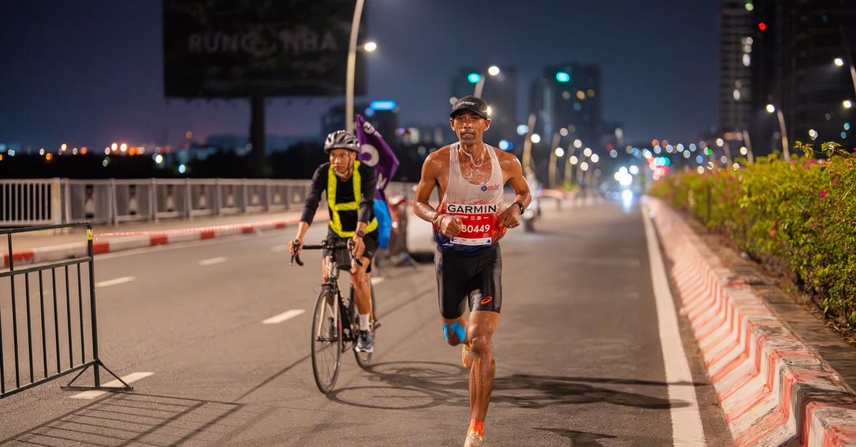 Marathon runner and cyclist participate in a vibrant night city race.